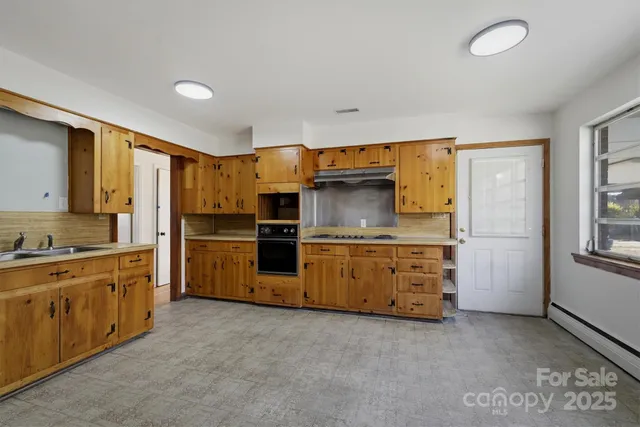 a kitchen with stainless steel appliances a stove a sink and a refrigerator