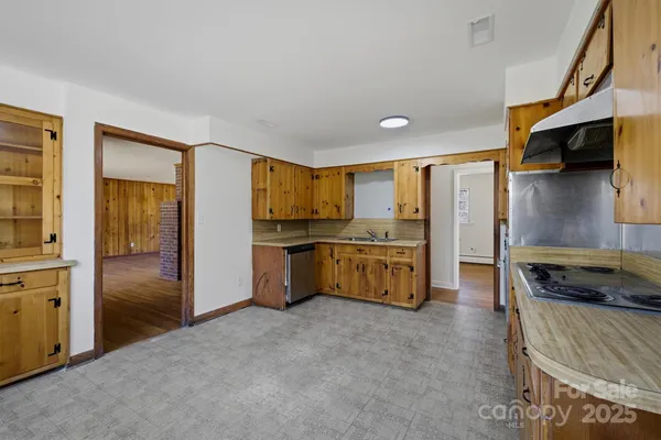 a kitchen with stainless steel appliances kitchen island granite countertop a refrigerator and a stove top oven