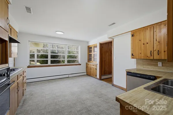 a view of a kitchen with a sink dishwasher and wooden floor