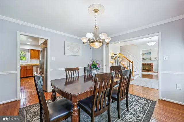 a dining room with furniture a chandelier and wooden floor