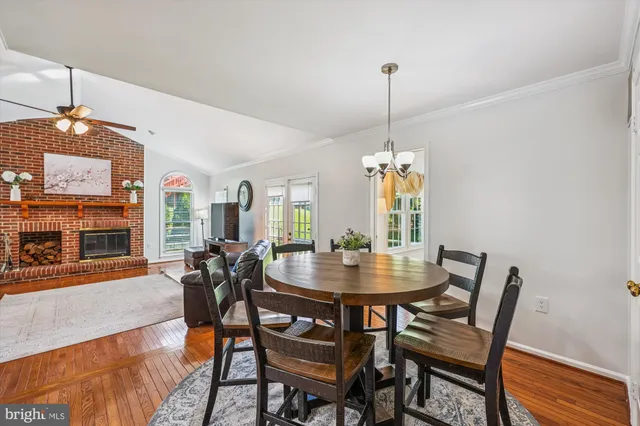 a living room with furniture and a dining table with wooden floor