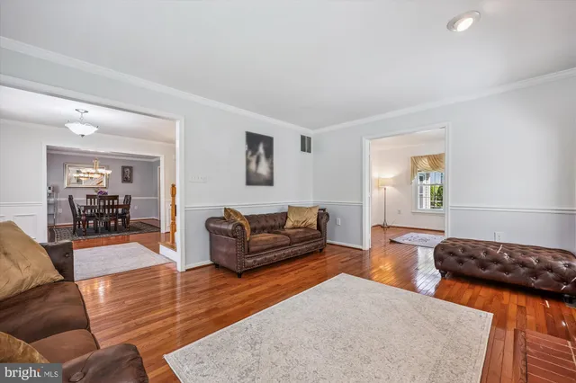 a kitchen with stainless steel appliances granite countertop a stove top oven a dining table and chairs with wooden floor