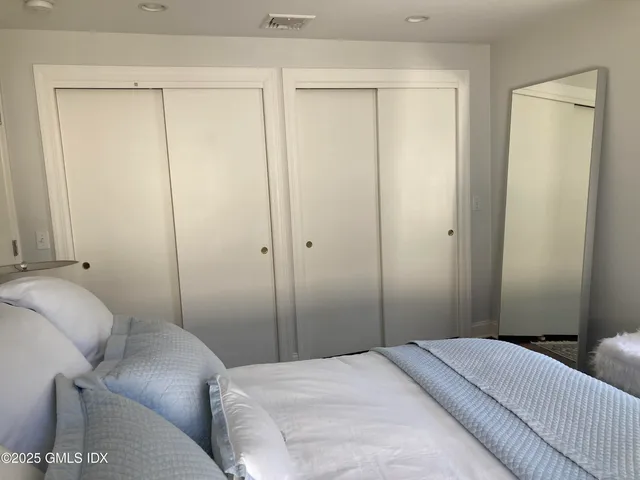 a large bed sitting in a bedroom next to a window