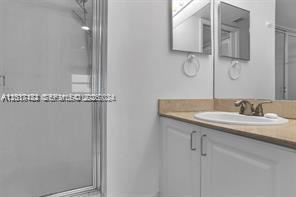 90 Alton Road, Unit 2303 Miami Beach, FL 33139 - Photo 24 of 29 a bathroom with a granite countertop sink and a mirror