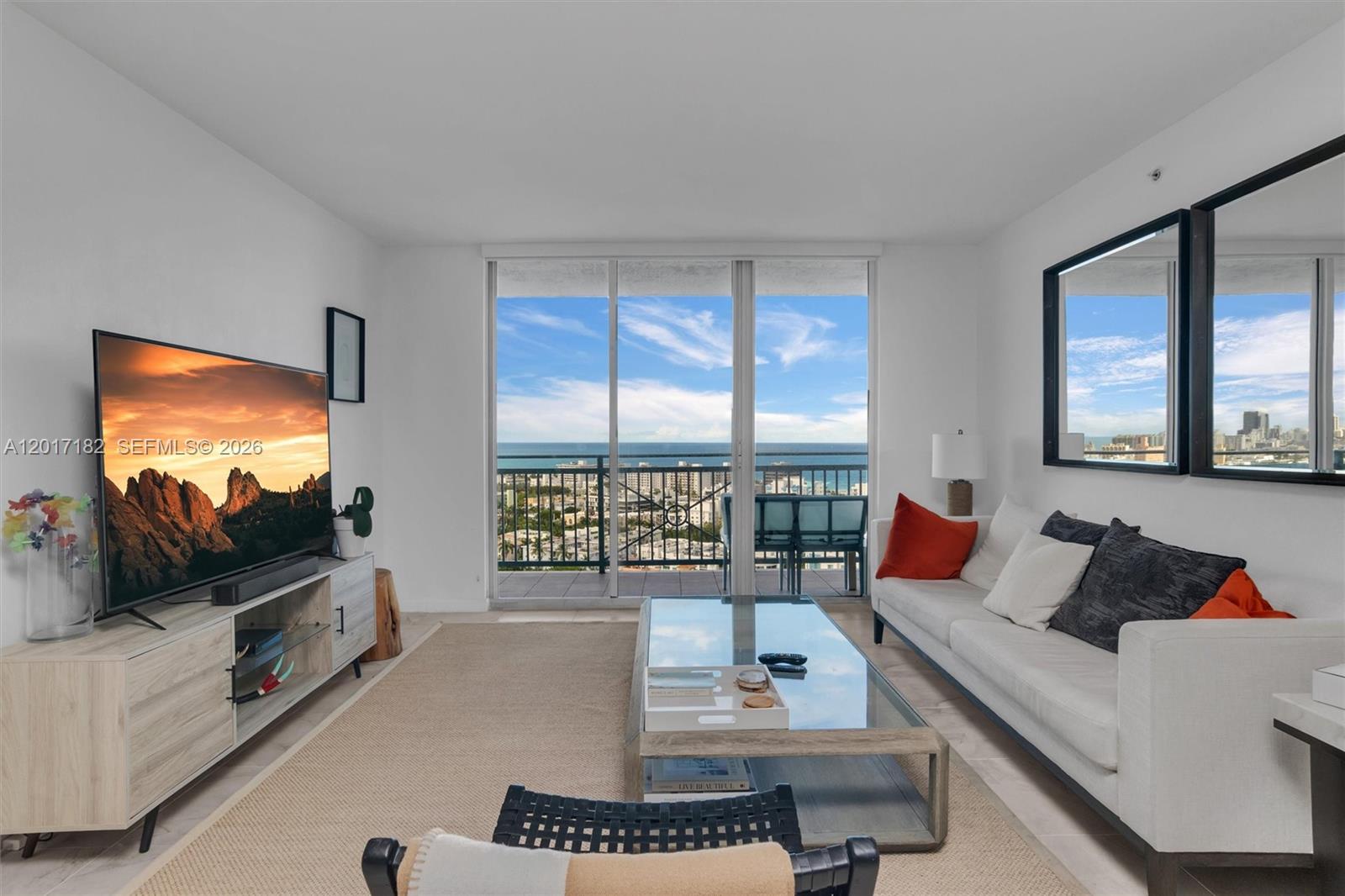 90 Alton Road, Unit 2303 Miami Beach, FL 33139 - Photo 5 of 29 a living room with furniture and a flat screen tv