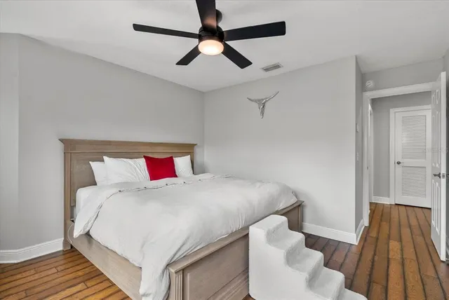 a bedroom with a bed and wooden floor