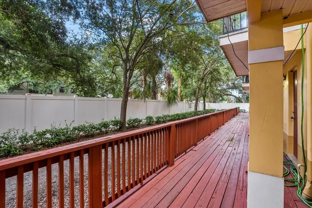 a view of a balcony with wooden floor and fence