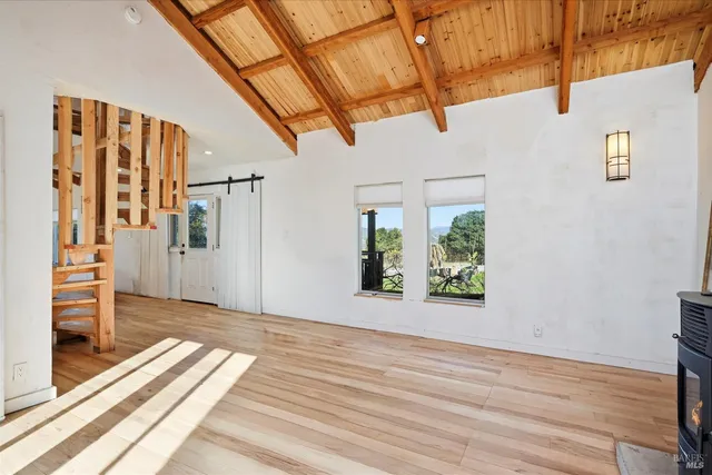 wooden floor with a kitchen view and a window