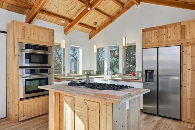 a kitchen with stainless steel appliances granite countertop a stove a refrigerator and a microwave