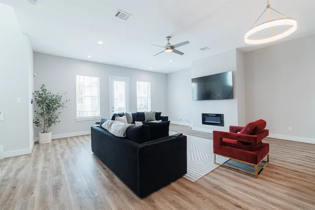 a living room with furniture a flat screen tv and a fireplace