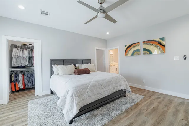 a bedroom with a large bed and a chandelier
