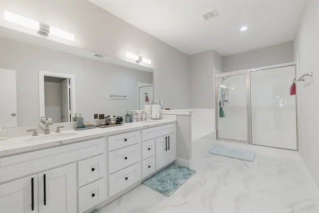 a spacious bathroom with double sink and a mirror