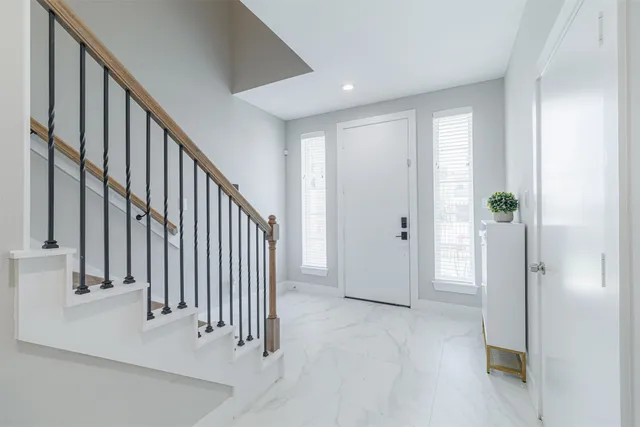 a view of a hallway with entryway and stairs