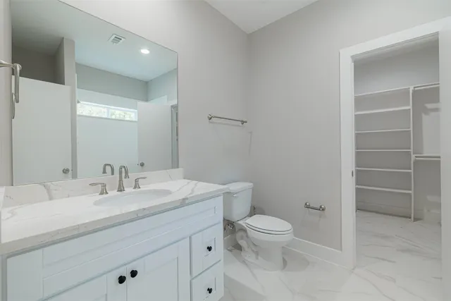 a bathroom with a toilet a sink and mirror