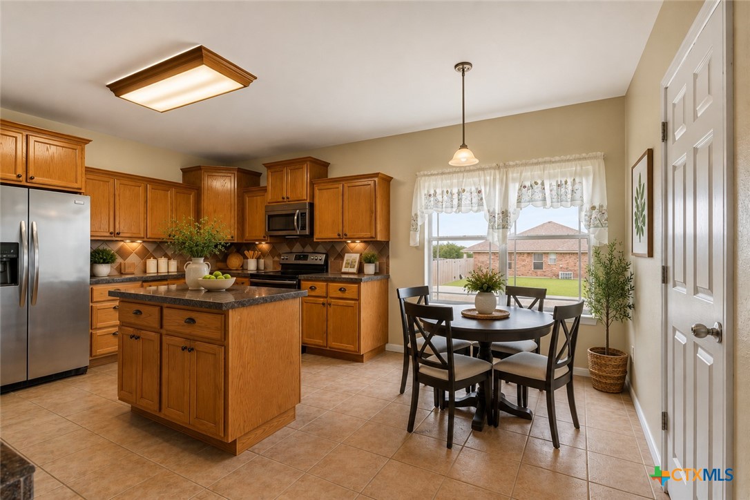 283 County Road 4710 Kempner, TX 76539 - Photo 13 of 47 a kitchen with stainless steel appliances kitchen island granite countertop a table chairs and a refrigerator