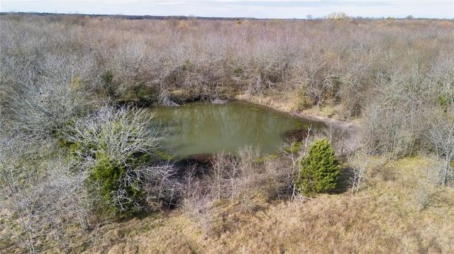 a view of a dry yard with wooden fence