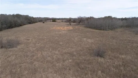 a view of a field with trees in the background
