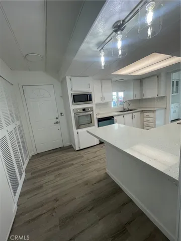 a large kitchen with stainless steel appliances a large counter top