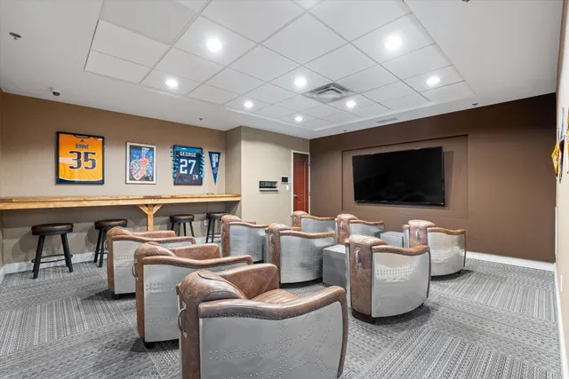 a living room with furniture a flat screen tv and kitchen view