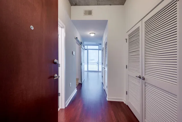 a view of a hallway with wooden floor