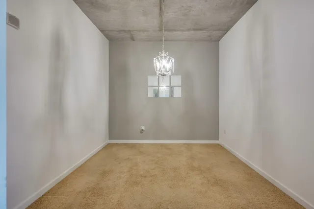 an empty room with windows and chandelier