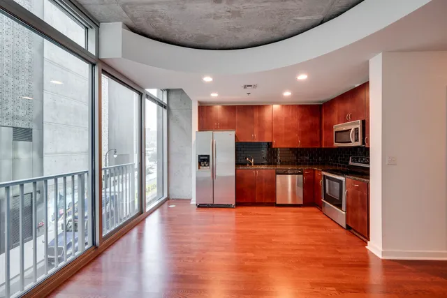 a large kitchen with stainless steel appliances kitchen island granite countertop a large stove a refrigerator and a view of living room