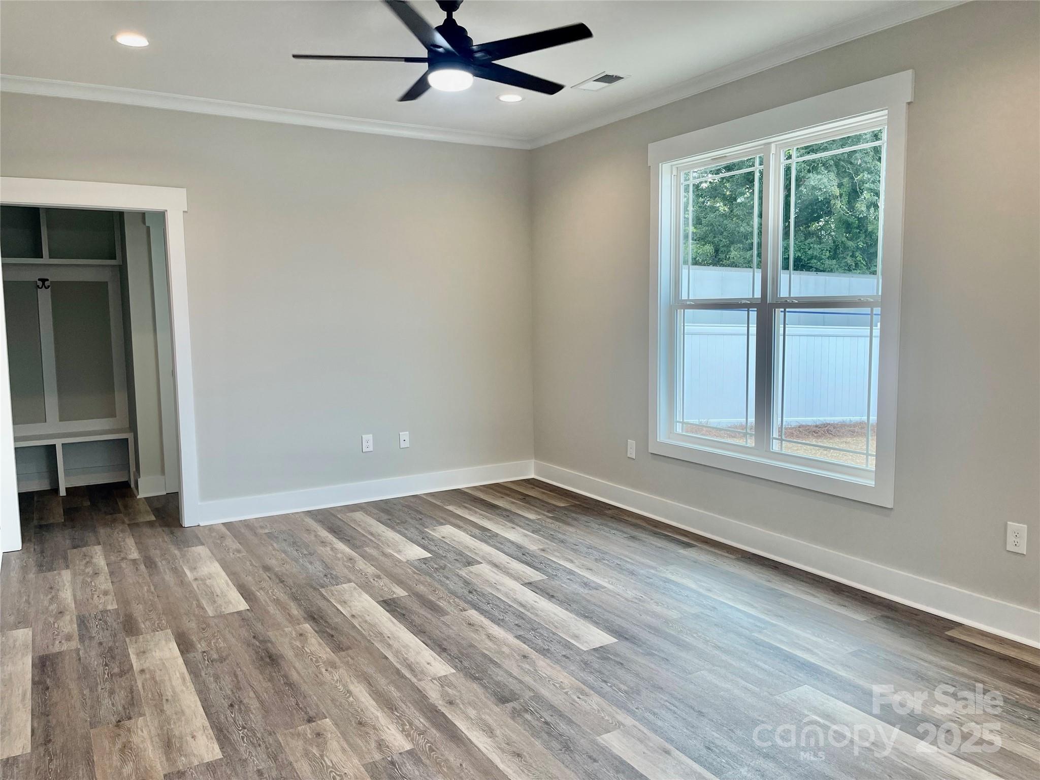 203 Prospect Church Road Albemarle, NC 28001 - Photo 11 of 44 an empty room with wooden floor fan and windows