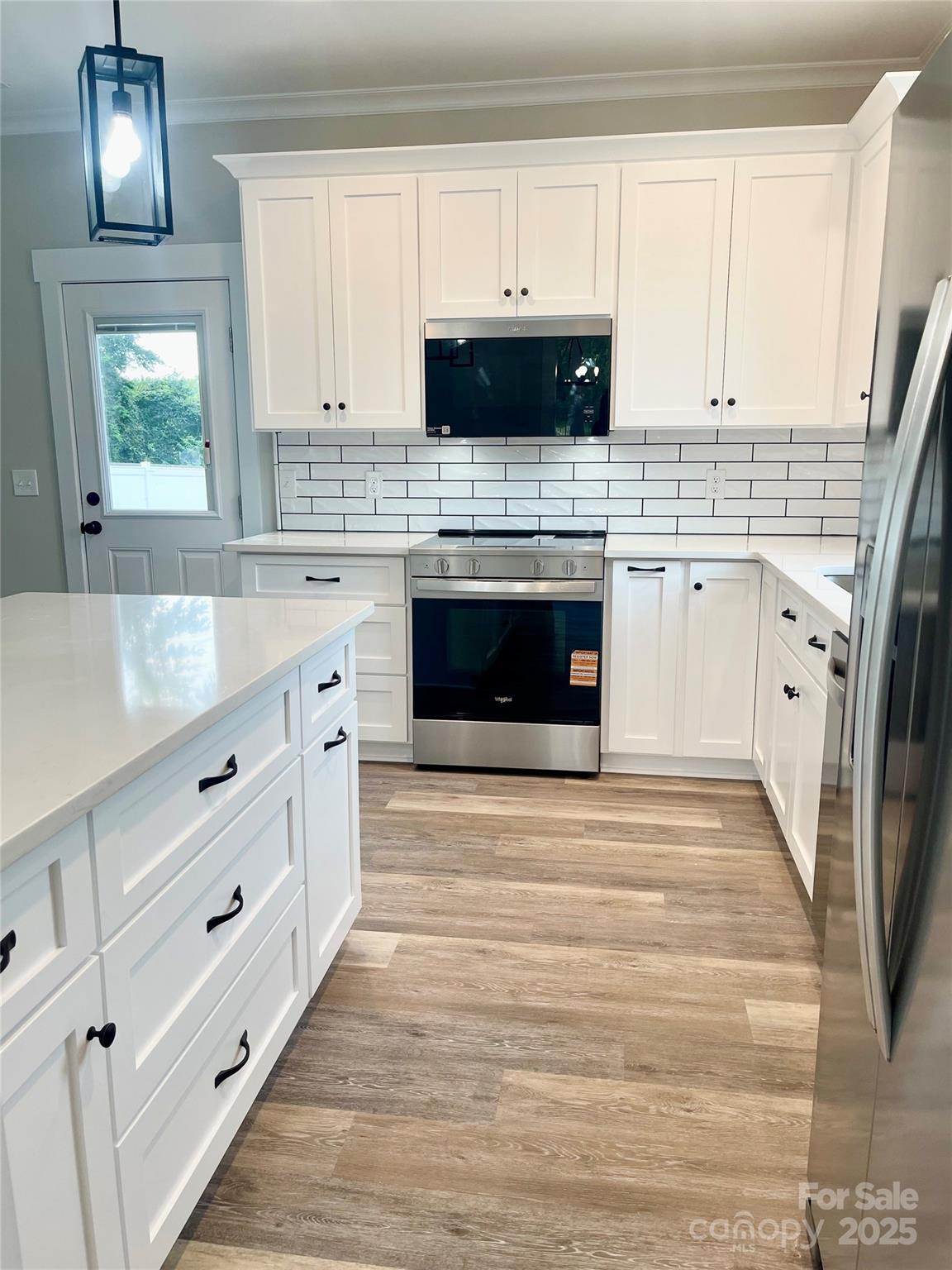 203 Prospect Church Road Albemarle, NC 28001 - Photo 9 of 44 a kitchen with stainless steel appliances a stove top oven a sink a window and white cabinets
