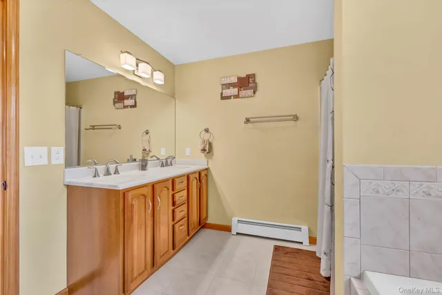 a bathroom with a granite countertop bathtub sink vanity mirror and toilet