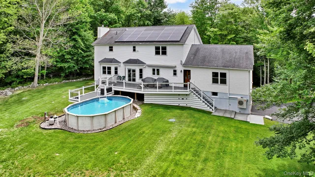a front view of house with yard and trees in the background