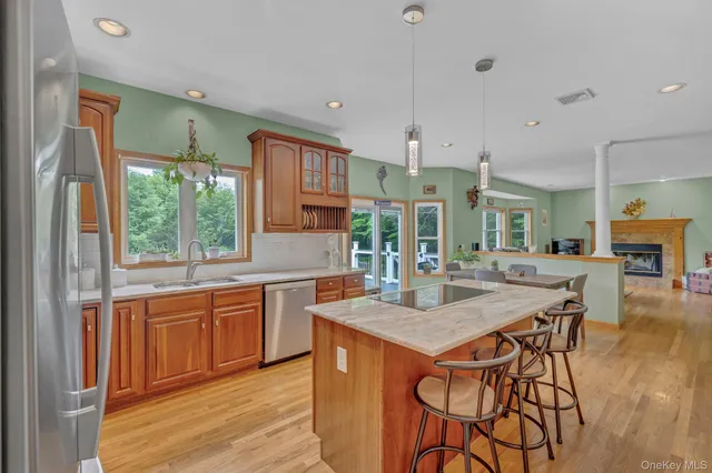 a kitchen with stainless steel appliances granite countertop wooden floor window and cabinets