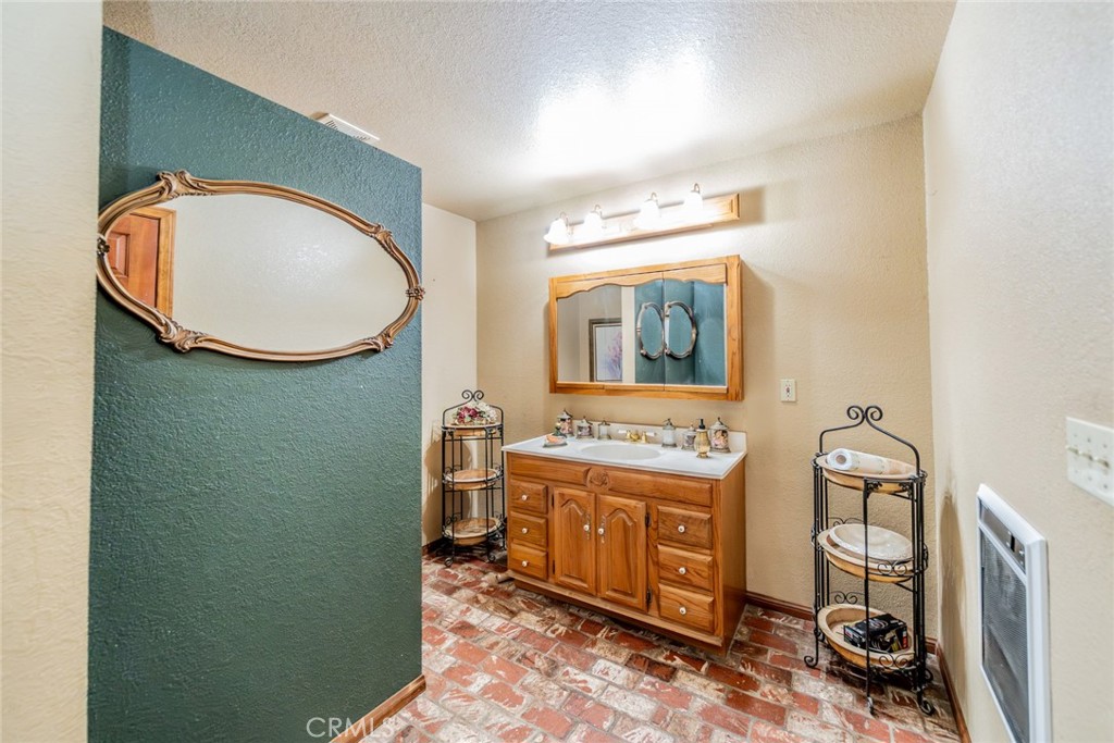 3230 Silver Ridge Drive Pinon Hills, CA 92372 - Photo 13 of 49 a bathroom with a toilet mirror vanity and a sink