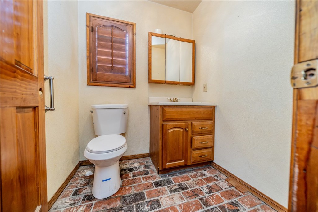 3230 Silver Ridge Drive Pinon Hills, CA 92372 - Photo 24 of 49 a bathroom with a toilet a sink and a window