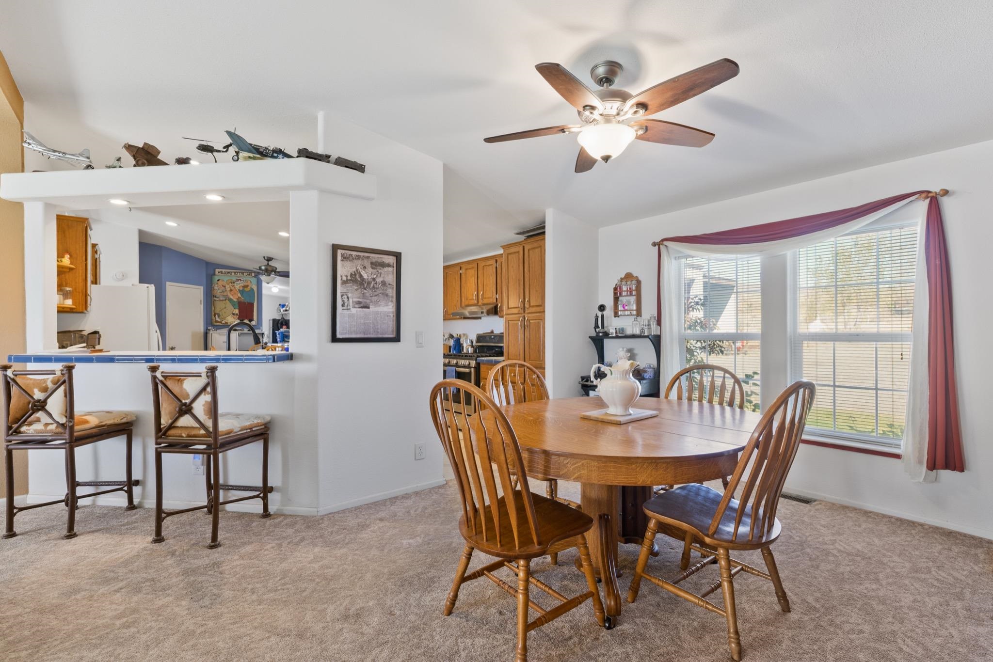 790 Cemetery Road Lee Vining, CA 93541 - Photo 14 of 39 Dining area with a bay window, ceiling fan with integrated lighting, and carpet flooring