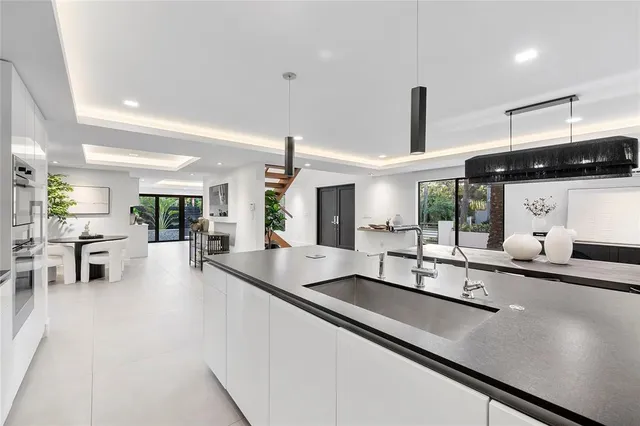 a kitchen with stainless steel appliances a sink and living room view