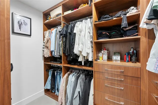 a view of walk in closet with clothes and shoes