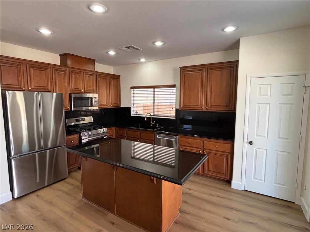 4900 Naff Ridge Drive Las Vegas, NV 89131 - Photo 4 of 21 A contemporary kitchen showcasing rich cabinetry, sleek countertops, and modern stainless steel appliances.