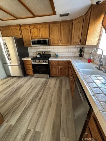 a kitchen with granite countertop a sink a stove top oven and cabinetry