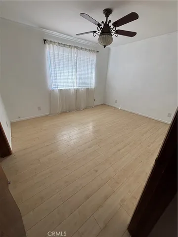 en empty room with windows and fan