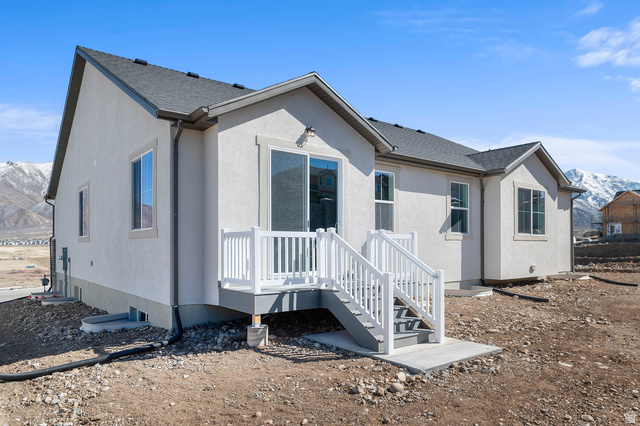 1024 South Tanner Road Santaquin, UT 84655 - Photo 3 of 20 Back of property with a deck with mountain view, a shingled roof, and stucco siding