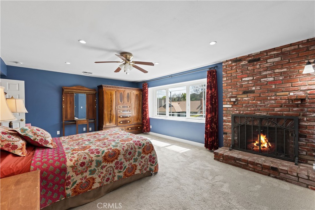 24405 Derian Drive Newhall, CA 91321 - Photo 29 of 44 a spacious bedroom with a bed and a fireplace