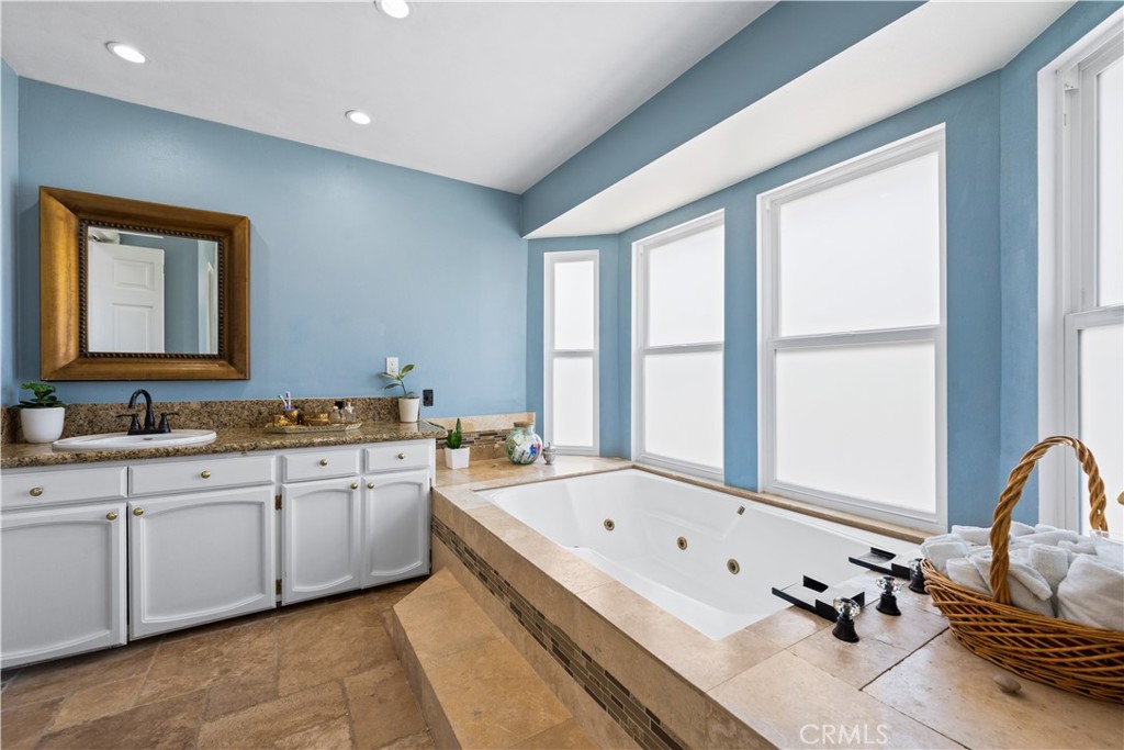 24405 Derian Drive Newhall, CA 91321 - Photo 30 of 44 a bathroom with a granite countertop tub sink and mirror