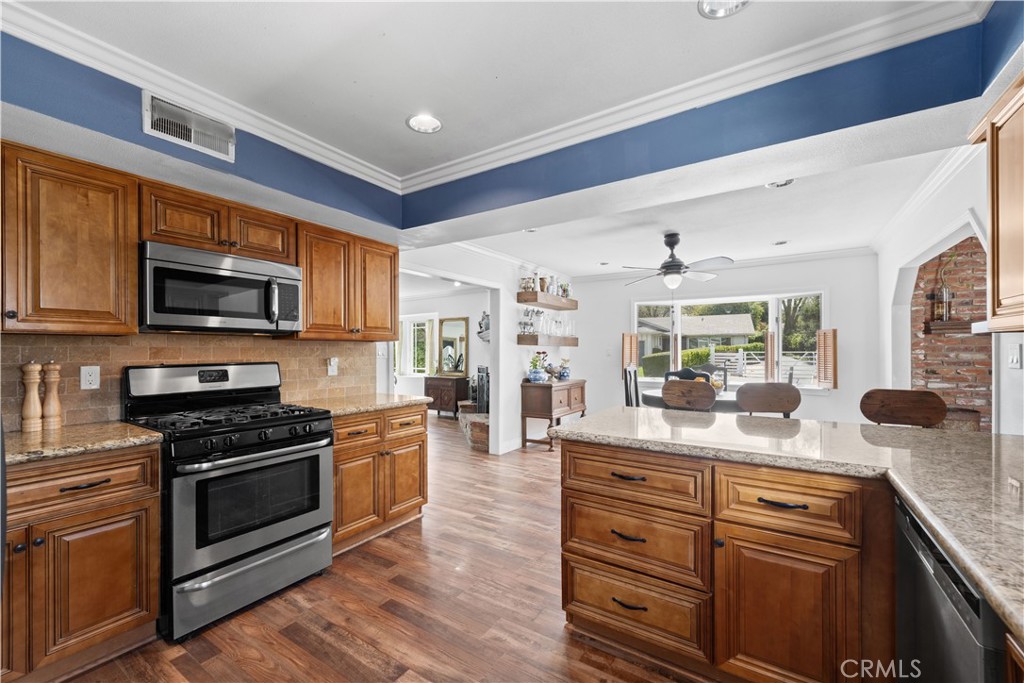 24405 Derian Drive Newhall, CA 91321 - Photo 10 of 44 a kitchen with a stove microwave and wooden floor