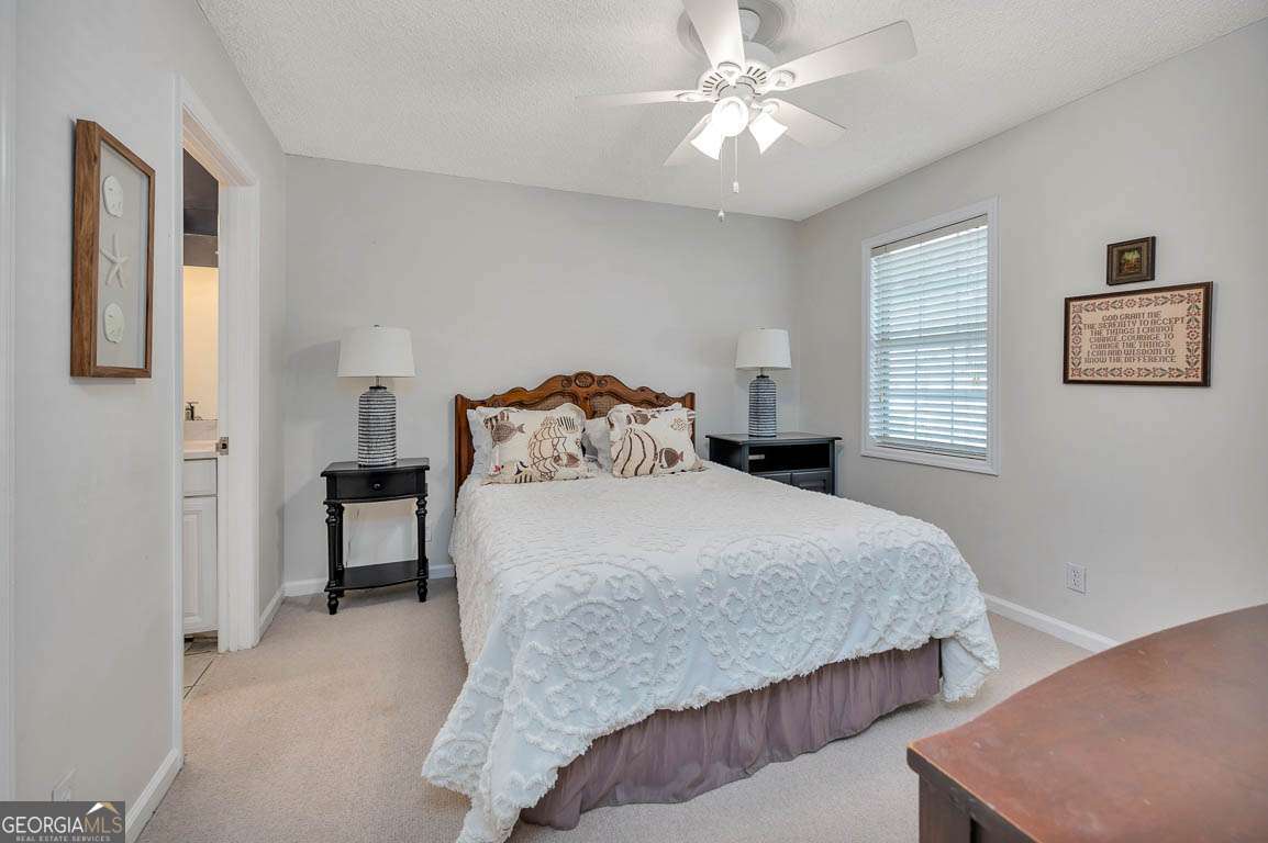143 South Island Square Drive St. Simons, GA 31522 - Photo 13 of 26 a bedroom with a bed and a chandelier