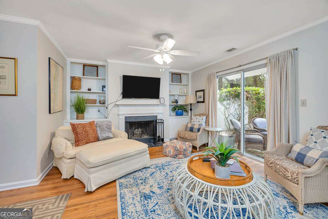 143 South Island Square Drive St. Simons, GA 31522 - Photo 4 of 26 a living room with furniture a fireplace and a flat screen tv
