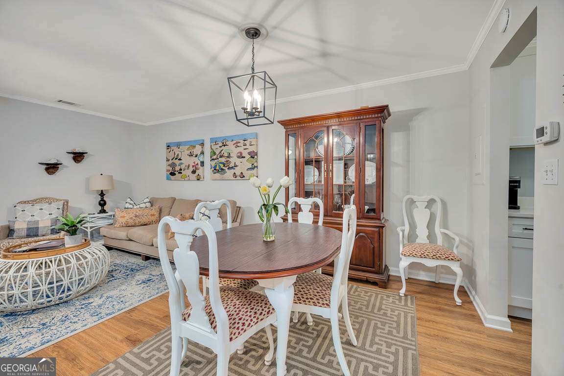 143 South Island Square Drive St. Simons, GA 31522 - Photo 9 of 26 a view of a dining room with furniture wooden floor and chandelier