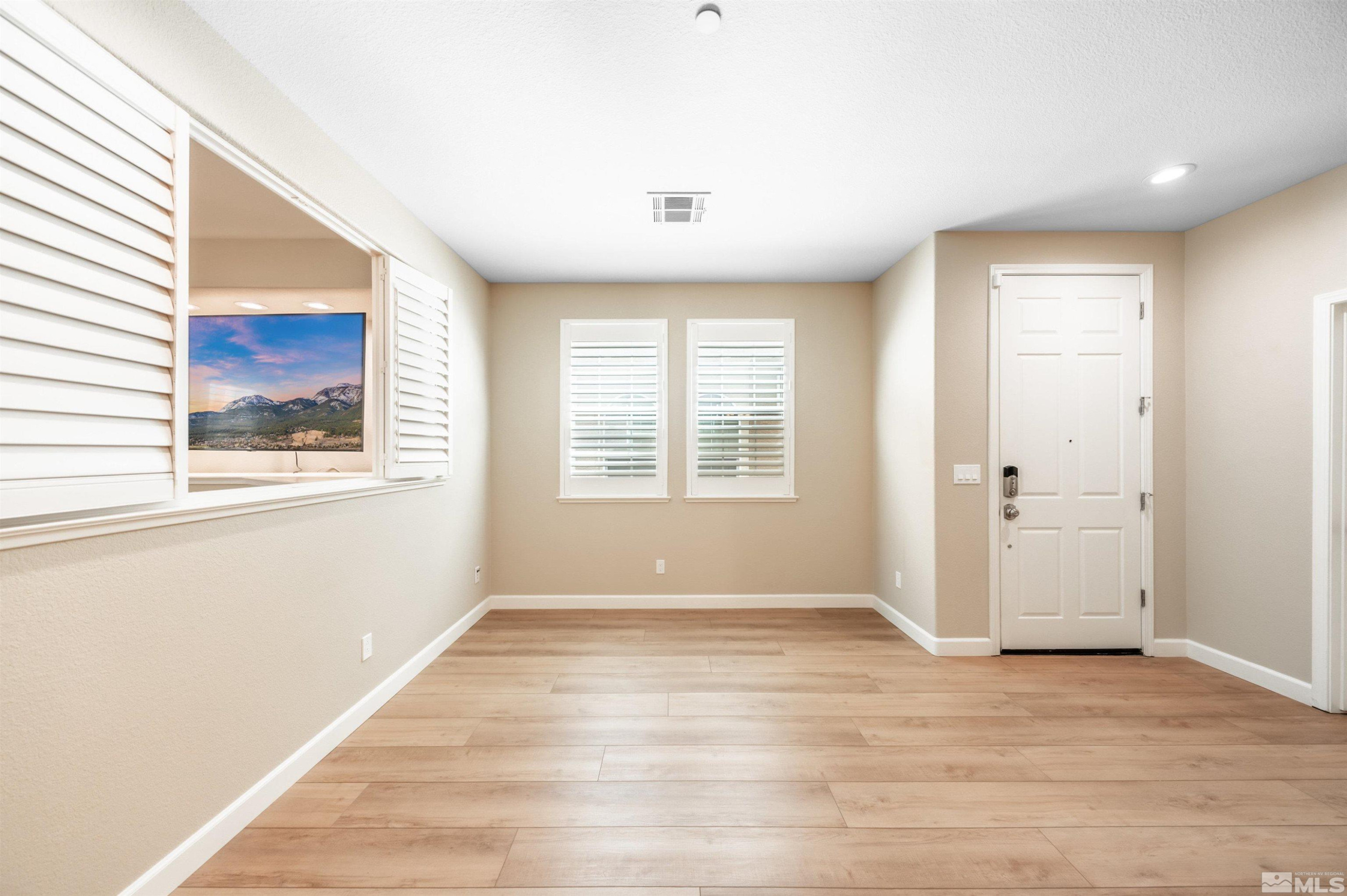 1835 Wind Ranch Road, Unit B Reno, NV 89521 - Photo 9 of 38 a view of an empty room with wooden floor and a window