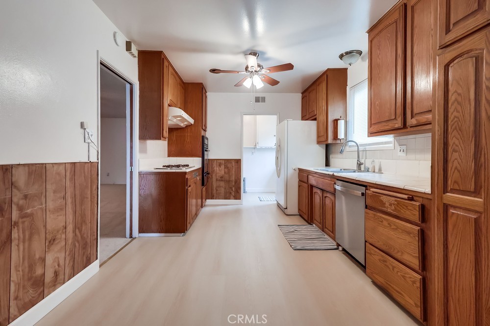 11639 Harvard Drive Norwalk, CA 90650 - Photo 12 of 33 a kitchen with stainless steel appliances granite countertop a refrigerator a sink dishwasher a stove and a dining table with wooden floor