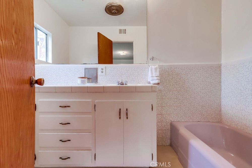 11639 Harvard Drive Norwalk, CA 90650 - Photo 23 of 33 a bathroom with a bathtub sink vanity and mirror