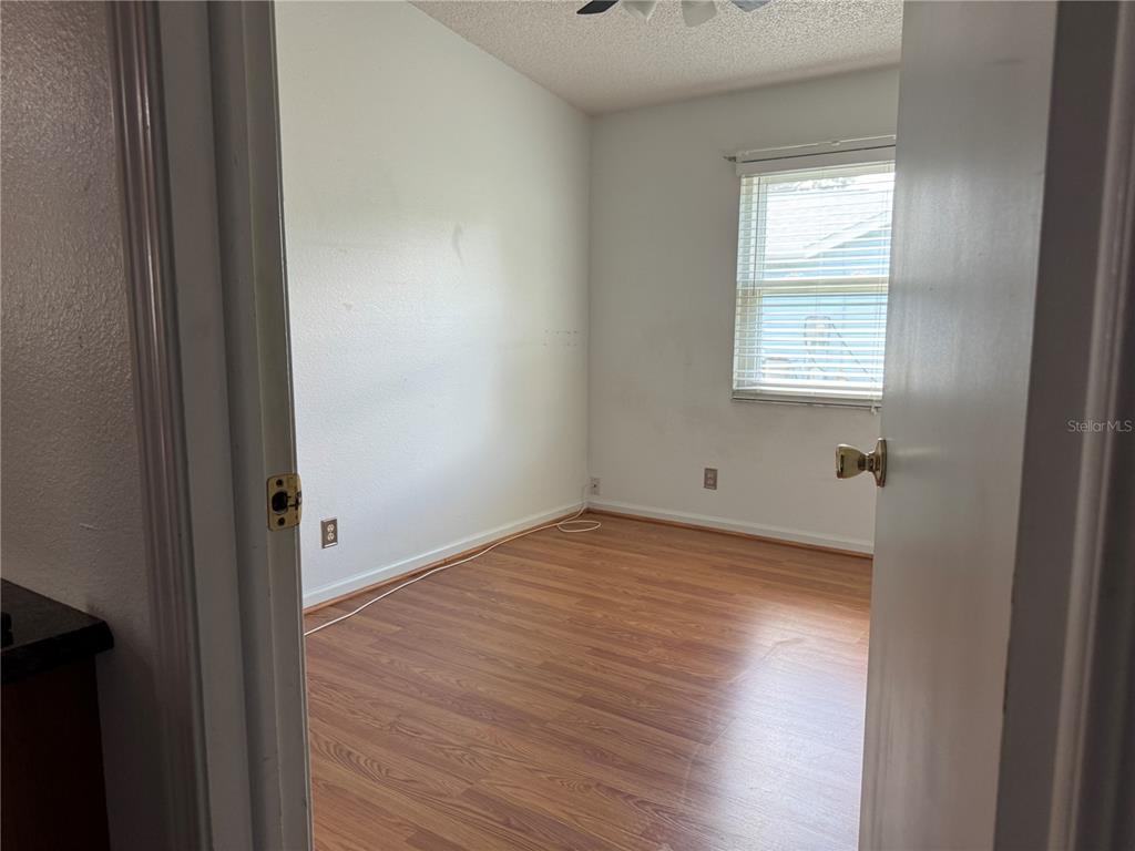 1605 Cherry Hill Road Lady Lake, FL 32159 - Photo 8 of 14 a view of an empty room with wooden floor and a window